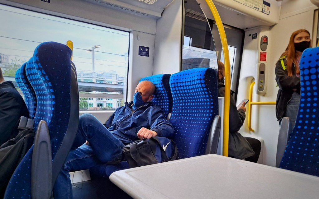 man sleeping on train with mask on