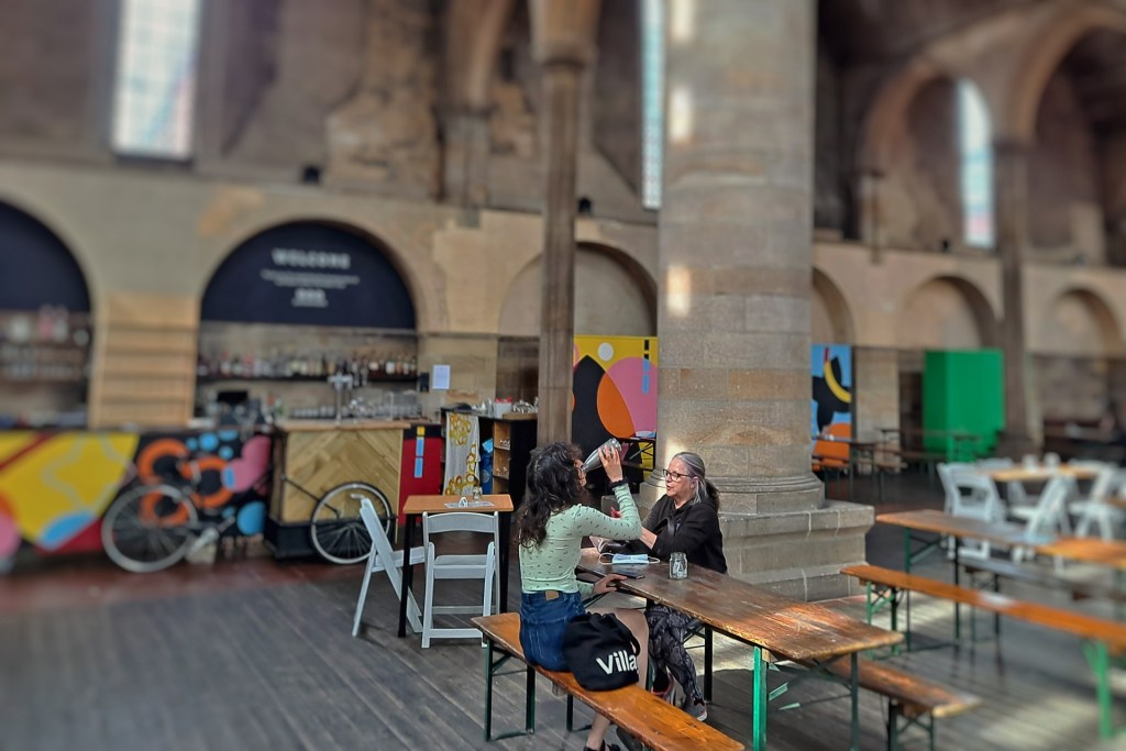 the inside of left bank showing the old church and the couple eating at a table