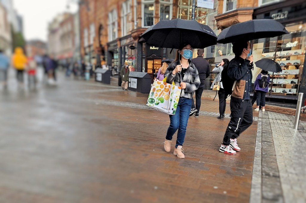 a couple walk in the rain with mask on