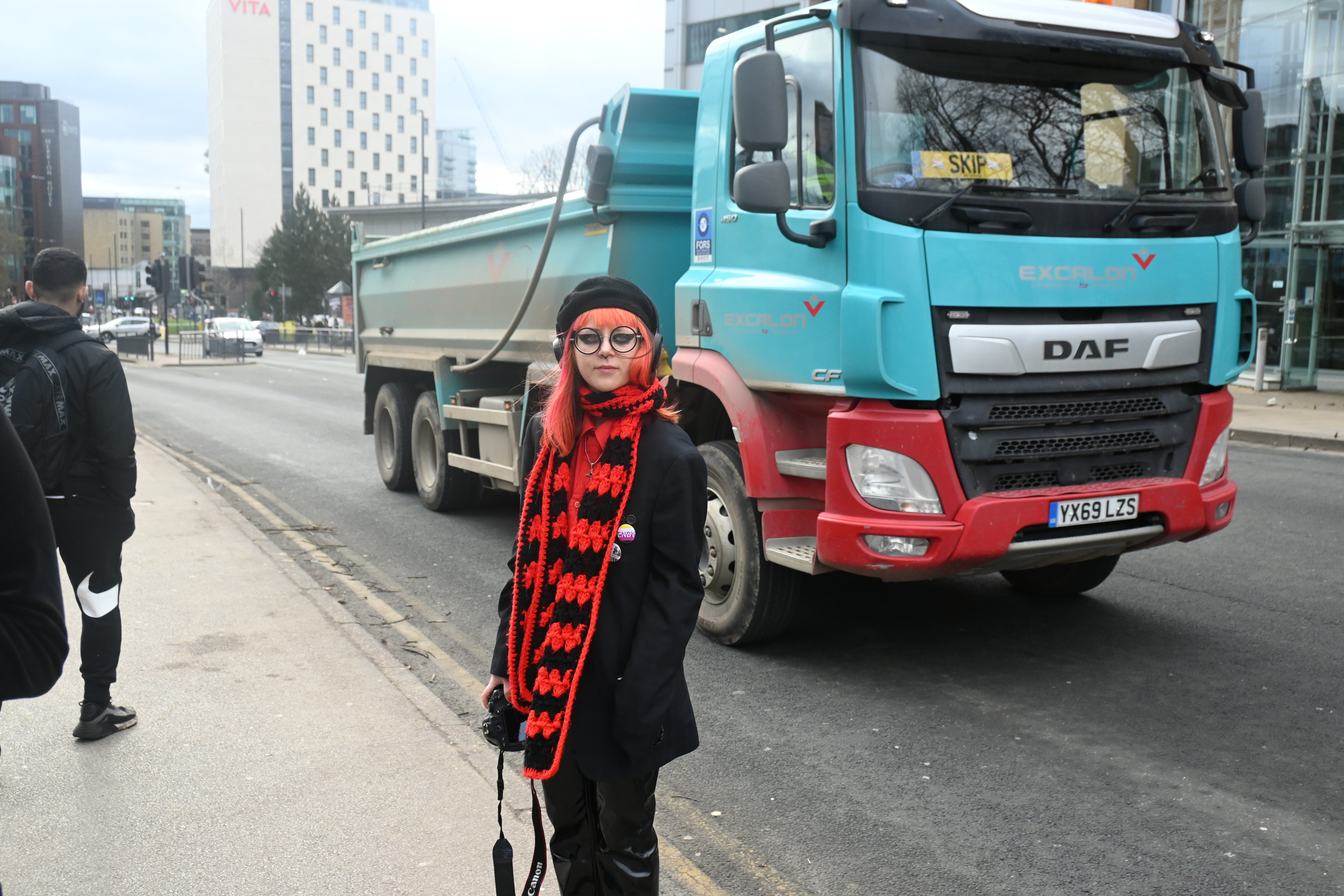 person standing in road with truck driving behind them