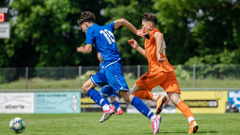 Players playing football on a sunny day