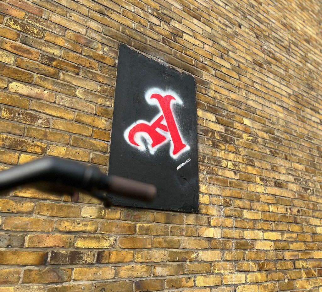 A piece of artwork on Gillespie Road. Highbury by local artist 'Northbanksy' on a brown brick wall. 