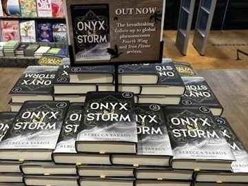 A stack of a newly released book on  display inside of a book shop.