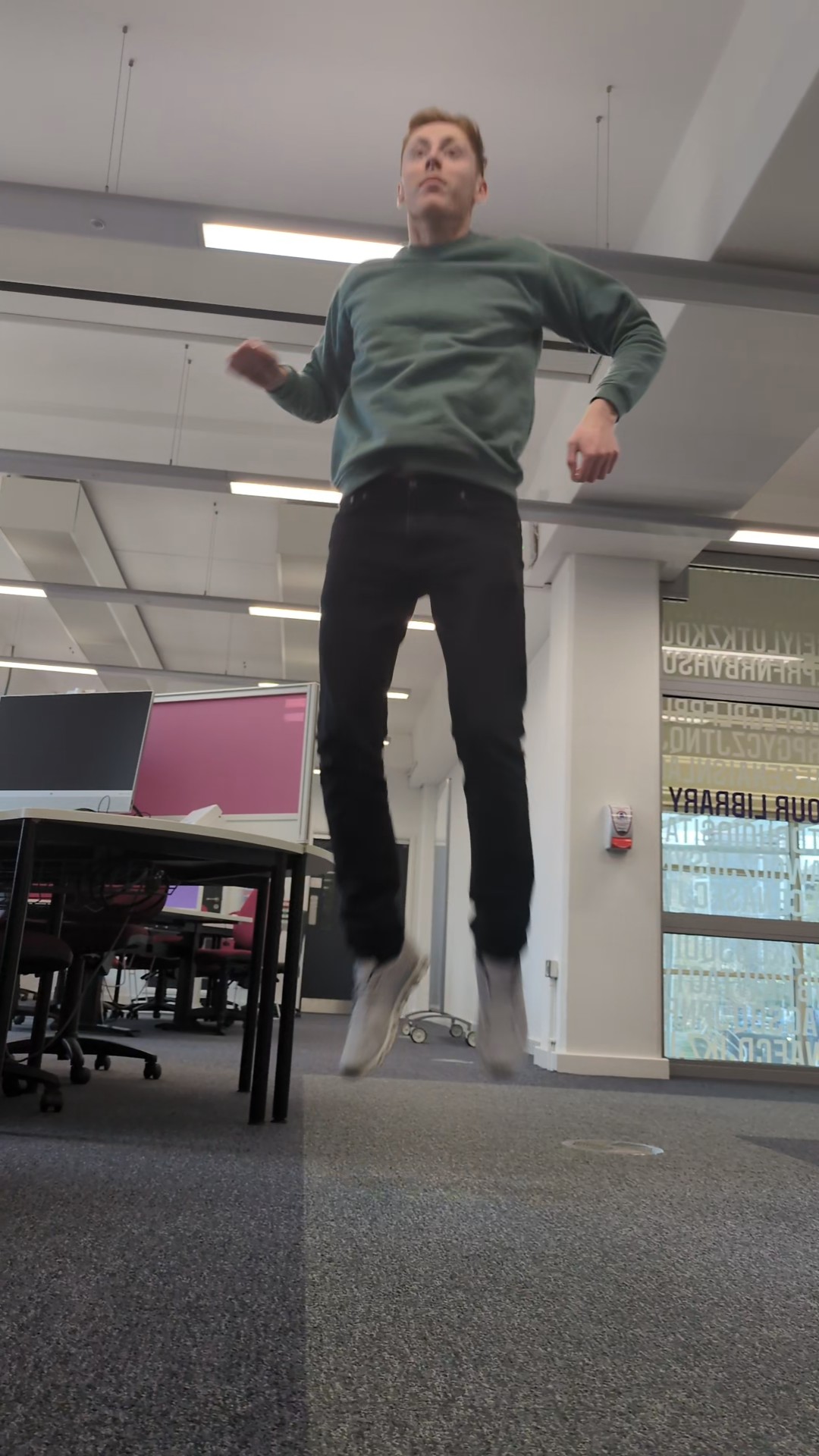Man completing jump in air, knees have straightened ,arms out and eyes forwards.
