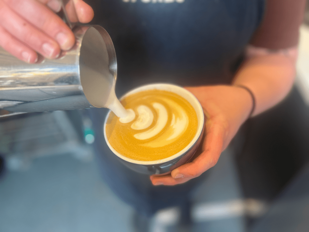 A latte having milk poured into it to create latte art