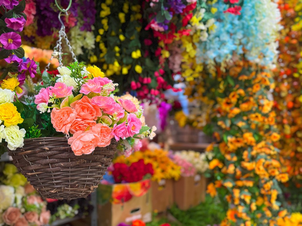 A display of coloruful artificial flowers hanging in a variety of bright hues at Kirkgate Market