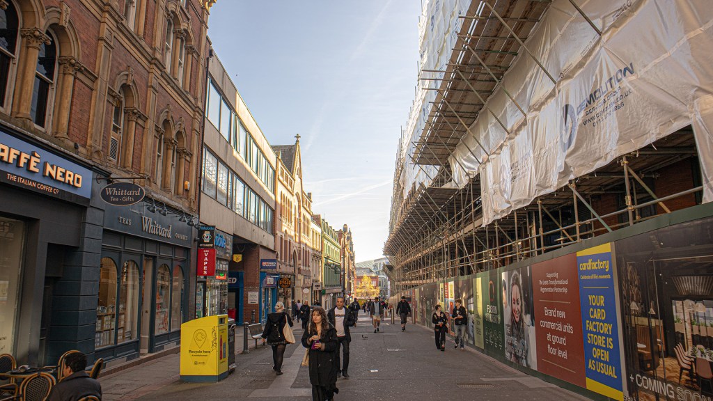 One side of the street developed with colorful buildings and businesses, the other under construction.   