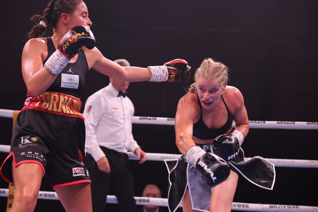 Willetts in black and red swings a left hook at ducking Gallagher who is wearing black gloves with black and silver shorts.