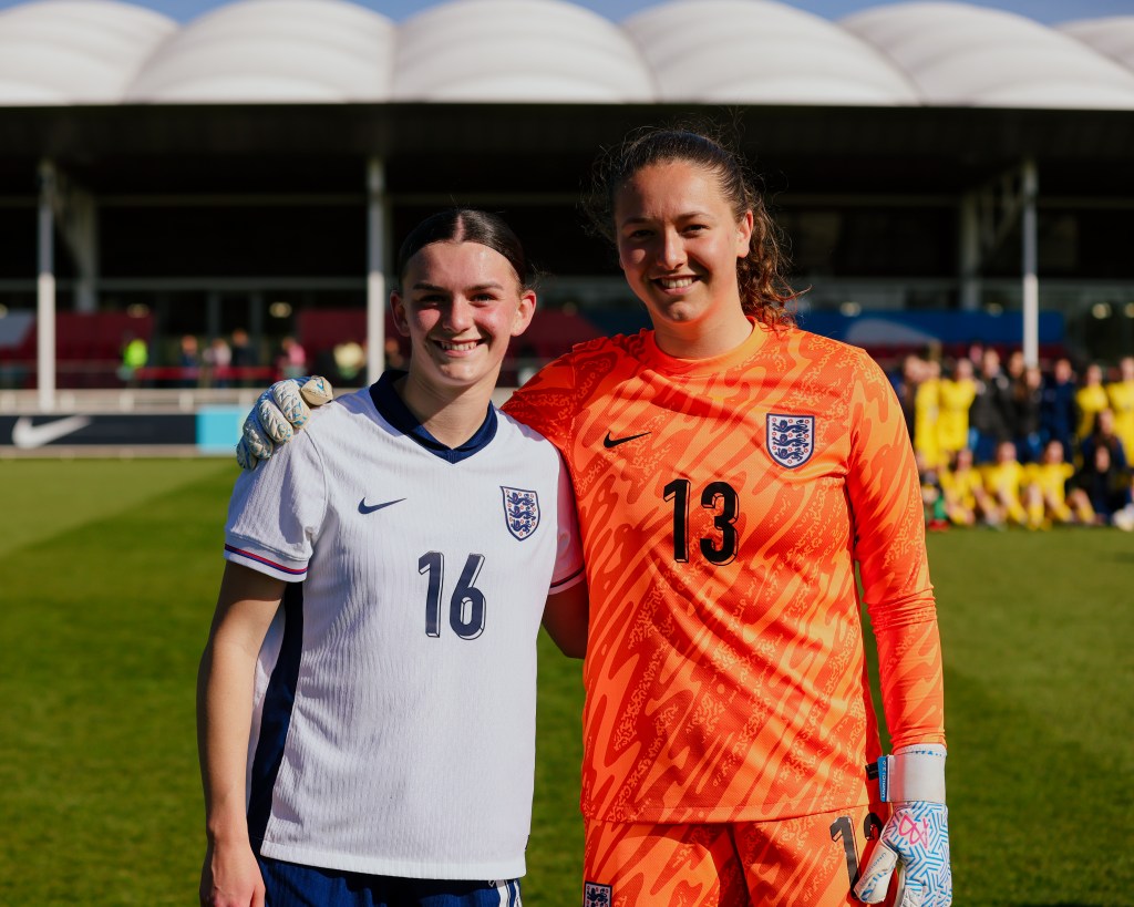 Two girls stood next to each other posing for a photo 