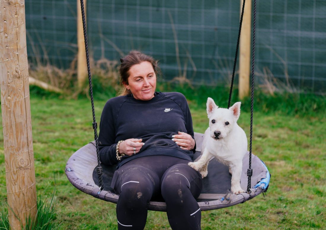 A woman and her dog on a swing