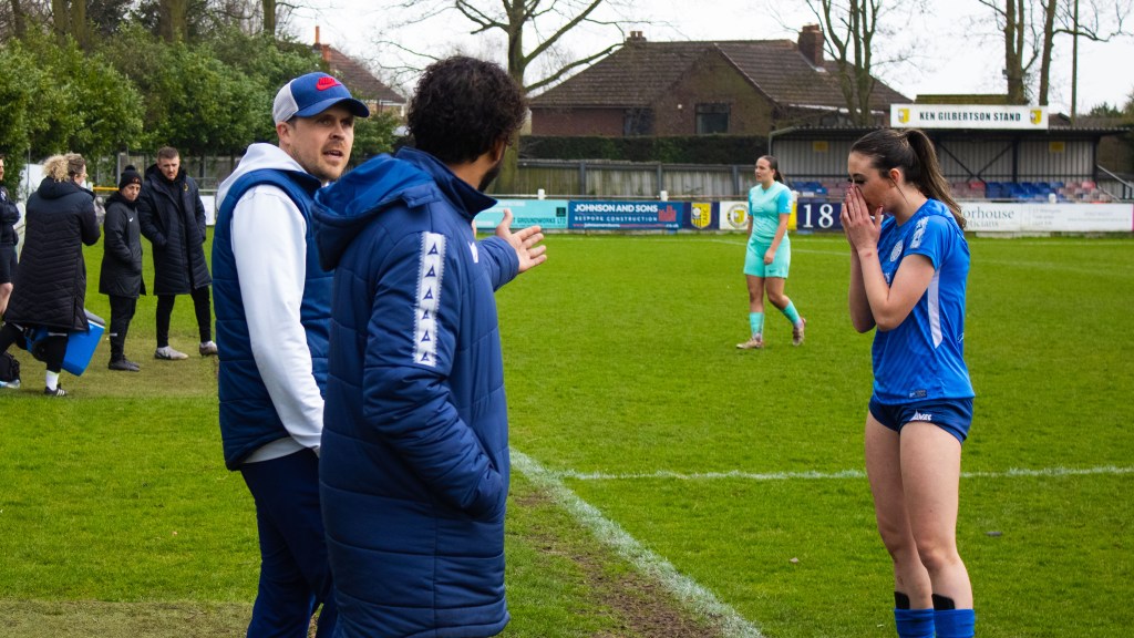 Rob Mitchell and Kevin Heetun coaching on the sidelines together with a player on the sidelines