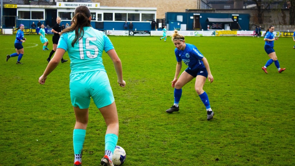Liverpool Feds player with the ball with Danielle Whitham defending her